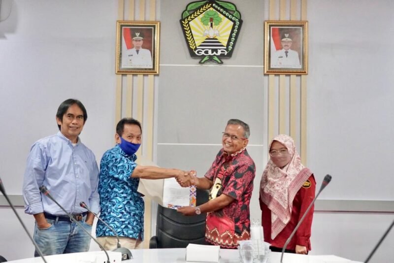 Kepala Dinas Komunikasi Informatika Statistik dan Persandian Kabupaten Gowa, Arifuddin Saeni didampingi Kepala Bidang Komunikasi Publik Diskominfo-SP Widiah Restuti Hasan  menerima hasil Monitoring dan Evaluasi (Monev) dari Ketua KI Sulsel di Peace Room A'Kio Kantor Bupati Gowa, Kamis (31/03/2022).