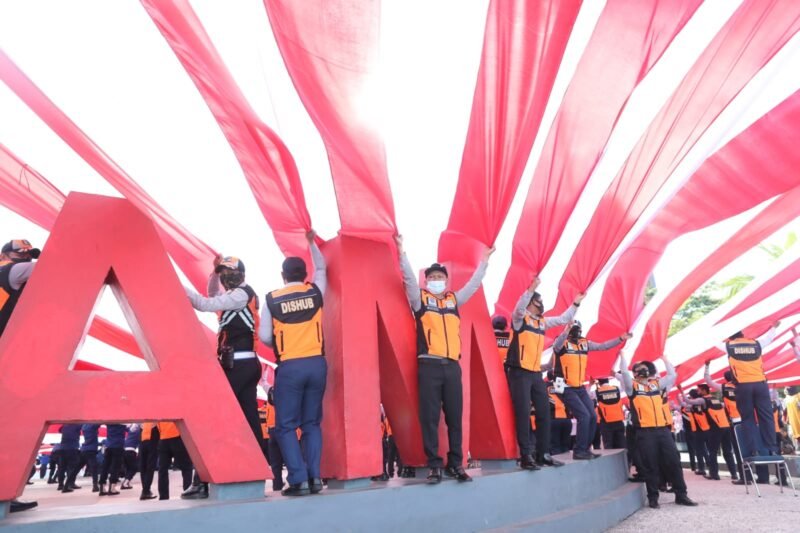 Personel Dishub Makassar ikut serta bentangkan Bendera Merah Putih di Anjungan Pantai Losari, Rabu (17/08/2022).