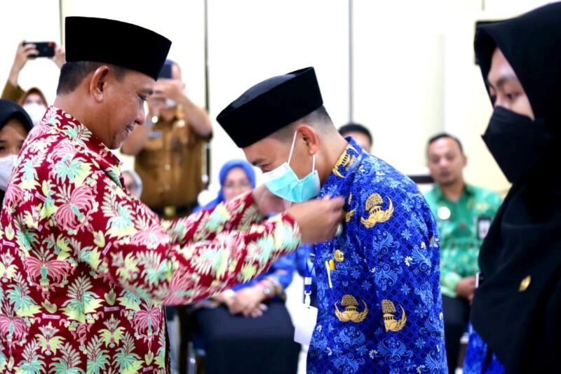 Bupati Wajo H. Amran Mahmud memsangkan atribut kepada perwakilan peserta pada pelatihan dasar (Latsar) Calon Pegawai Negeri Sipil (CPNS) formasi umum 2021 Kabupaten Wajo, di Kampus II BPSDM Prov Sulawesi Selatan, Makassar, Senin (19/9/2022).
