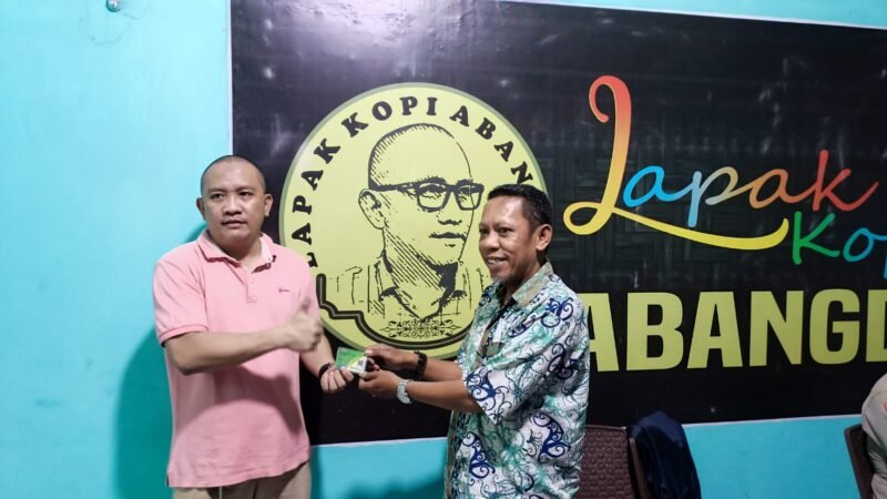 Kepala Unit Pasar Kampung Baru, Muhammad Fajaruddin serahkan kartu BPJS Ketenagakerjaan kepada para pedagang Pasar Kampung Baru, Jumat (11/11/2022).