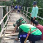 Babinsa Koramil 1406-08/Sabbangparu, Serka Lukman, melaksanakan kegiatan gotong royong bersama warga dalam perbaikan jembatan gantung di Desa Benteng Lompoe, Kecamatan Sabbangparu, Kabupaten Wajo, pada Sabtu (17/1/2026)