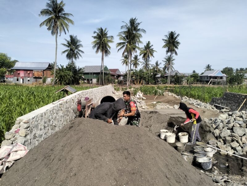 Babinsa Koramil 1406-08/Sabbangparu, Koptu Bakri, membantu masyarakat dalam pembuatan pondasi rumah bertempat di Dusun Caleko Alau Salo, Desa Wage, Kecamatan Sabbangparu, Kabupaten Wajo, pada Minggu (18/1/2026)