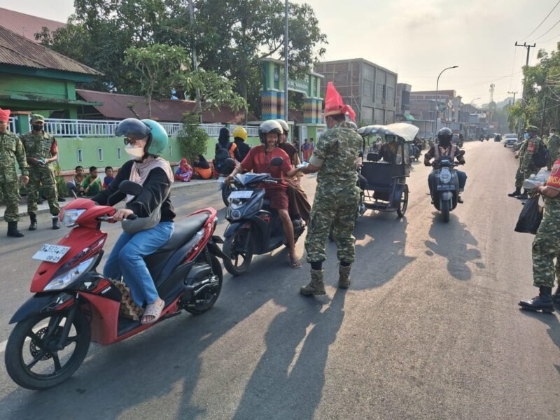 Personel TNI Kodim Wajo turun langsung membagikan masker gratis kepada para pengguna jalan dan pedagang di wilayah Kecamatan Tempe, Kabupaten Wajo, Jumat (16/10/2026)